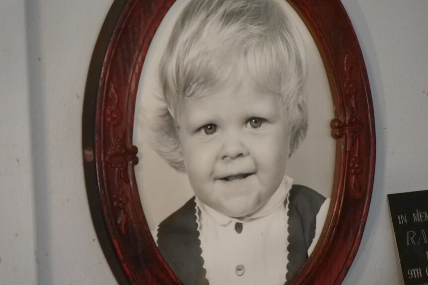 A baby photo of Jane Rimmer, in a wooden oval frame.