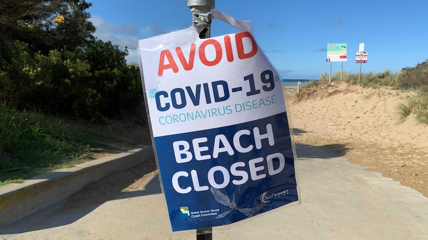 A sign at Anglesea beach saying 'avoid COVID-10 - beach closed'.