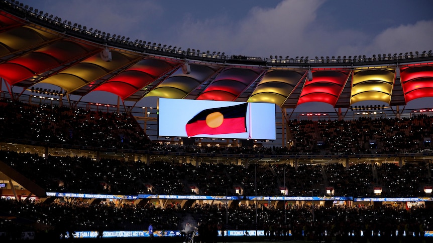 The Aboriginal flag on the screen at Optus Stadium in Perth before the AFL game between West Coast and Essendon.