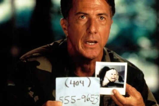 Outbreak film still showing Dustin Hoffman holding a picture of a monkey.