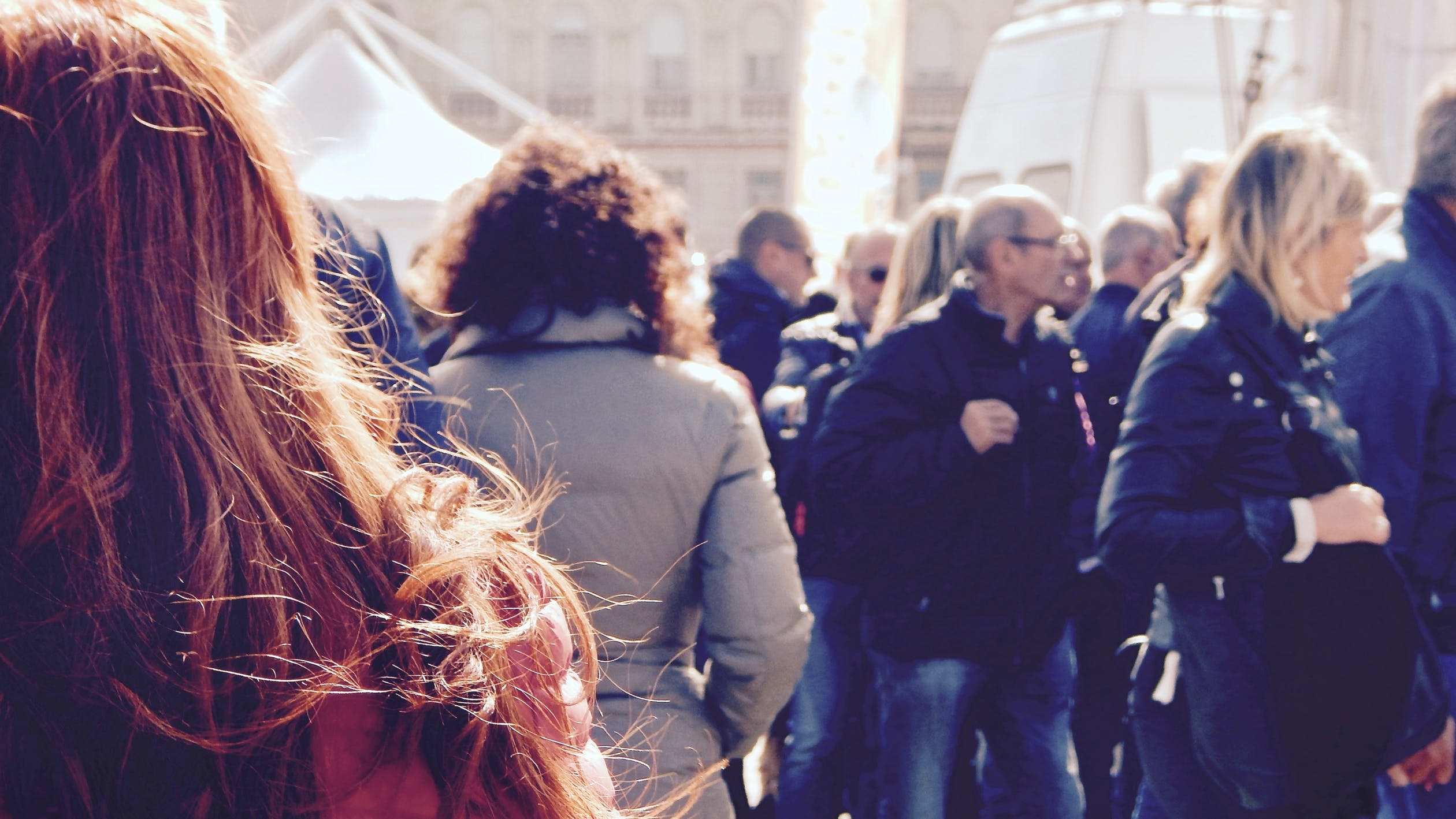 A crowd of people, all facing away from camera.