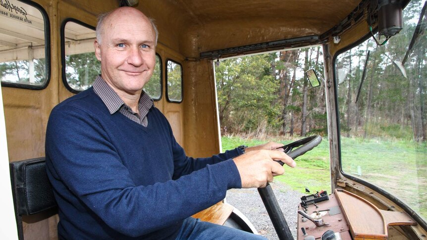 Mick Harris at the wheel of his British electric milk cart was built  to replace the horse and cart delivery method.