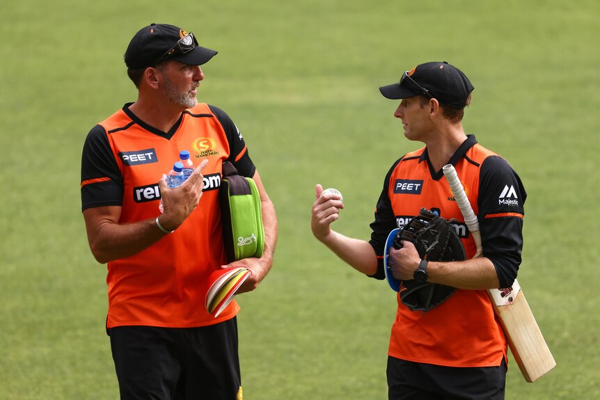 Matt Mason and Adam Voges talk while walking across the Perth Stadium grass.
