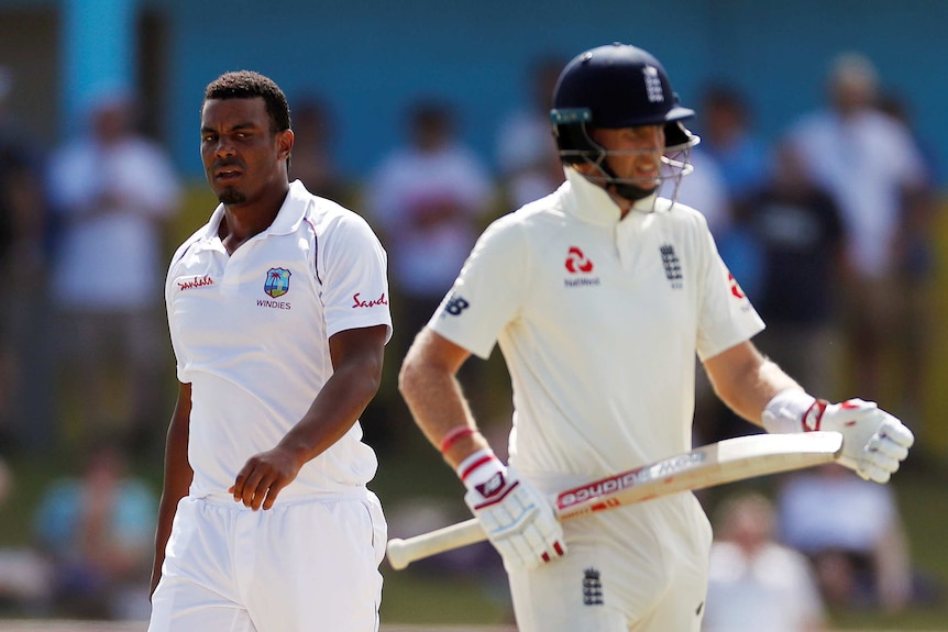 Shannon Gabriel looks to his left at Joe Root, who has his backed turned to Gabriel.