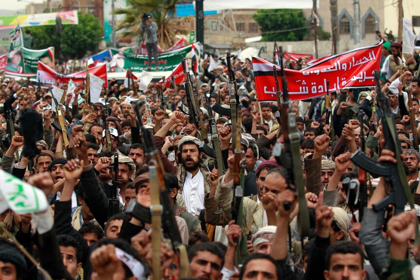 Supporters of the Shiite Houthi movement brandish their weapons during a demonstration