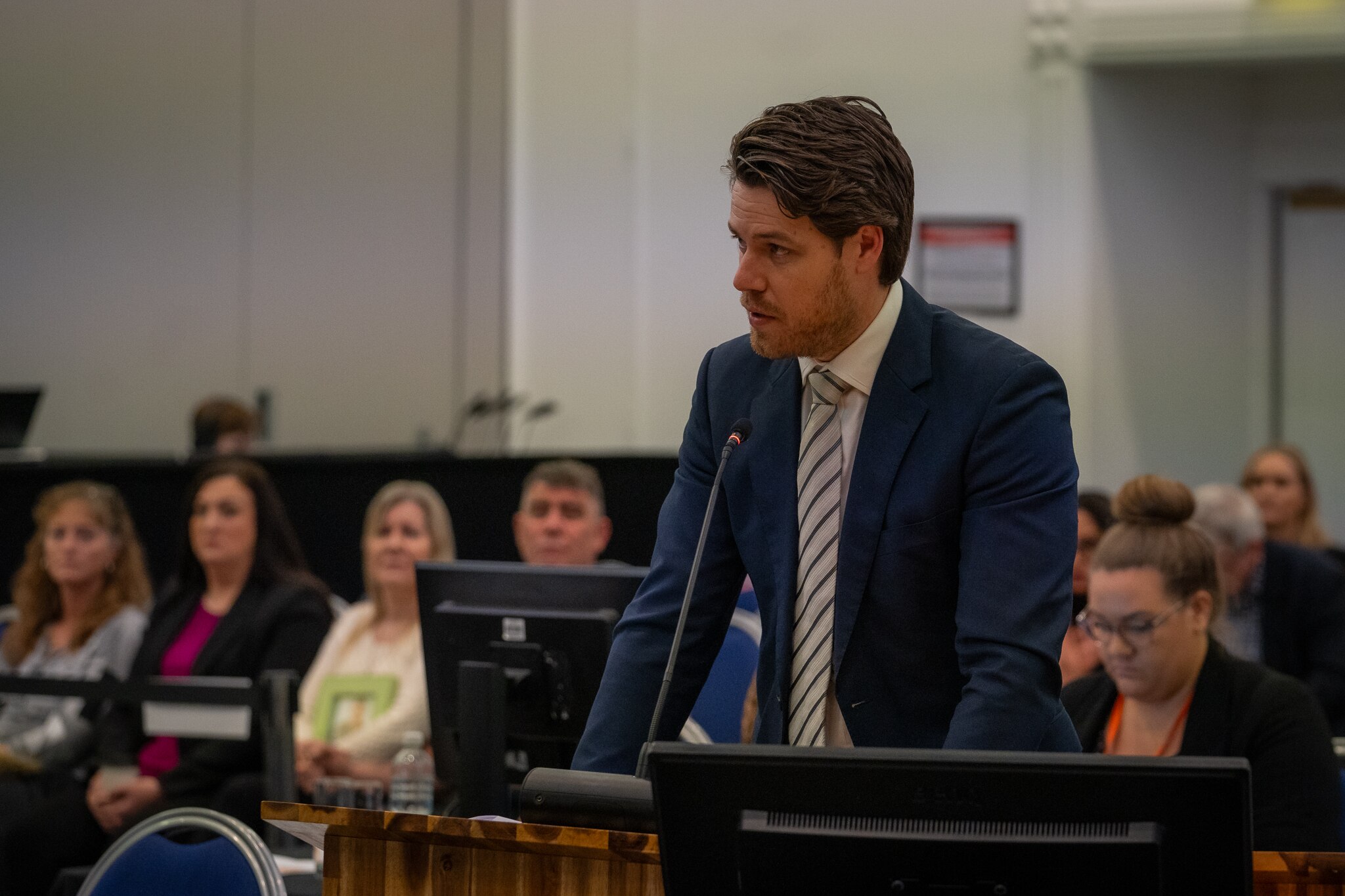A man in a suit in front of a microphone.