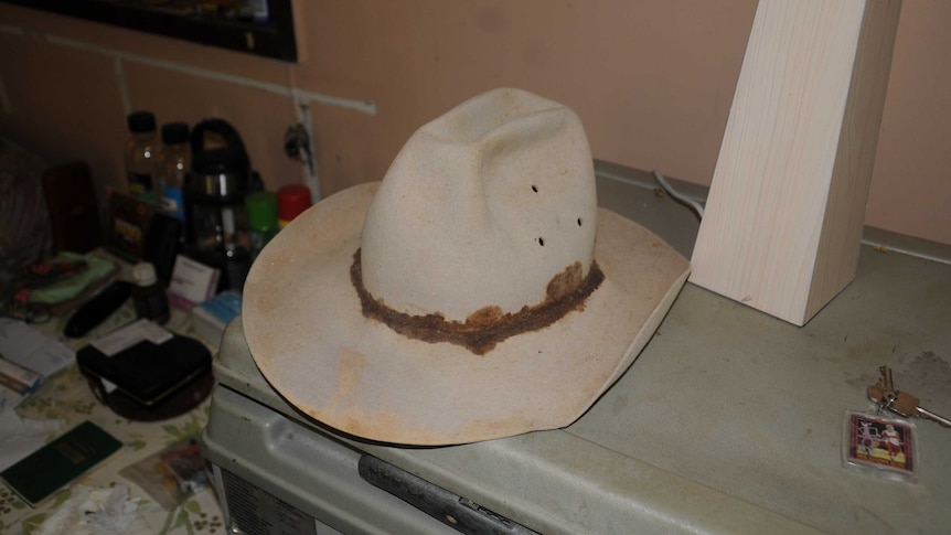 An old cowboy hat sitting on a fridge.