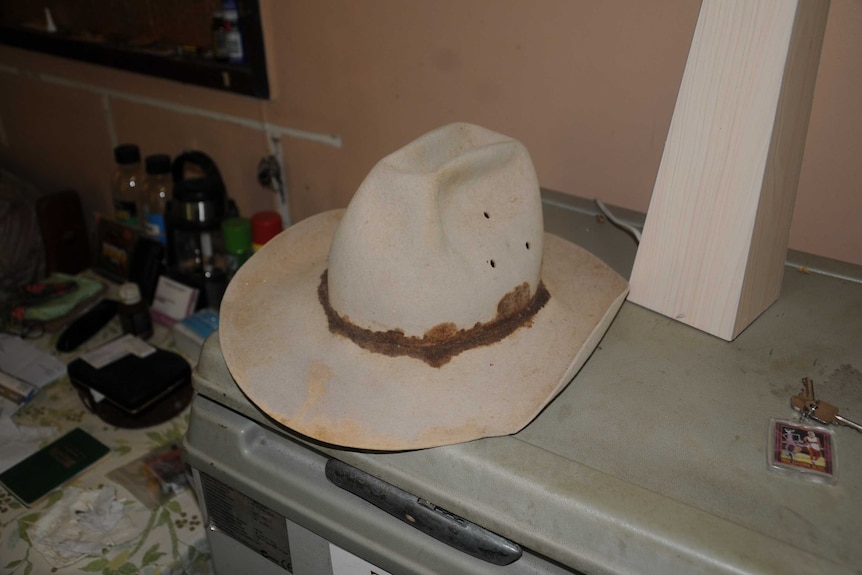 An old cowboy hat sitting on a fridge.