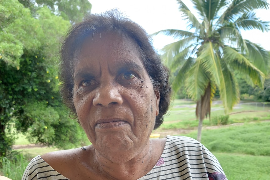 A photo of a woman with a palm tree in the background