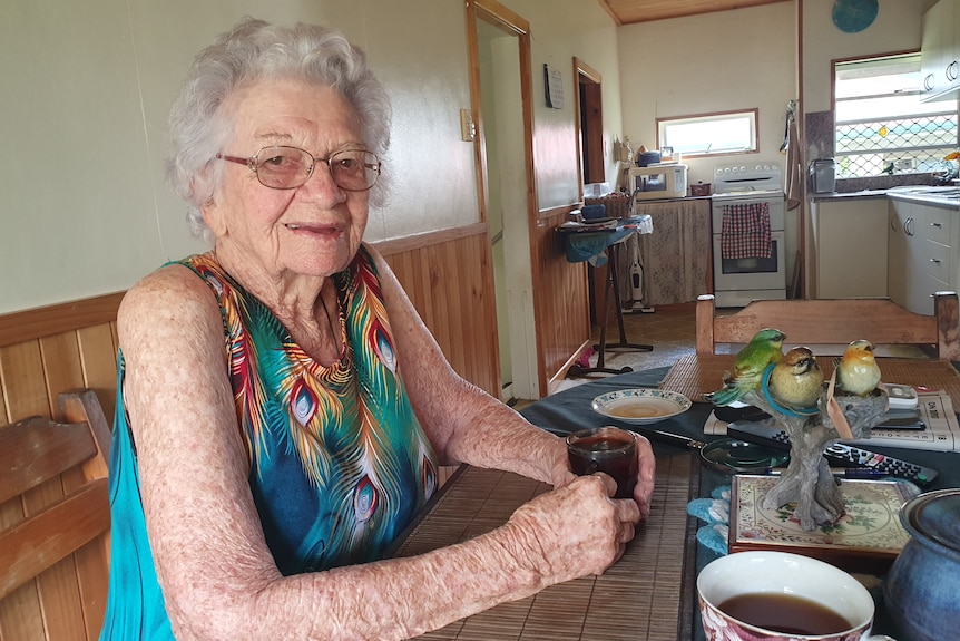 Older lady in glasses holding a cup of tea