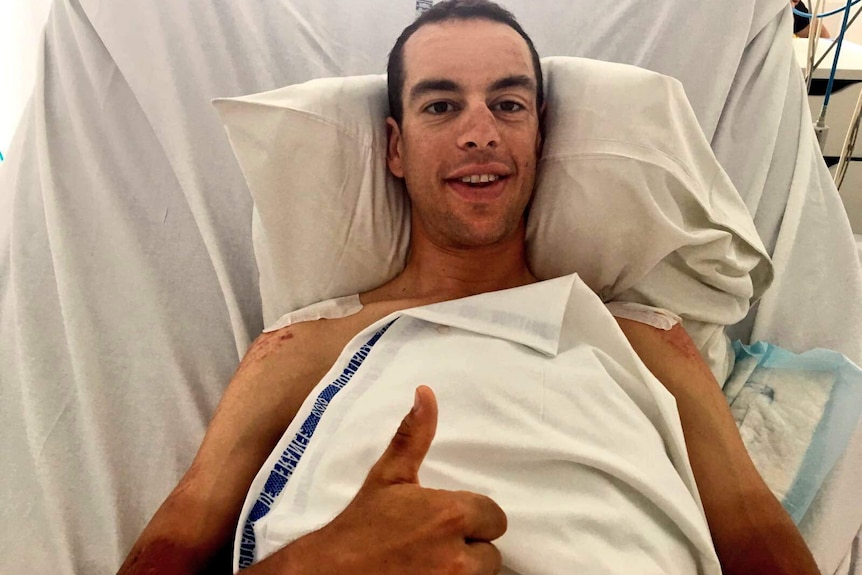 Richie Porte gives a smile and a thumbs up from his hospital bed.