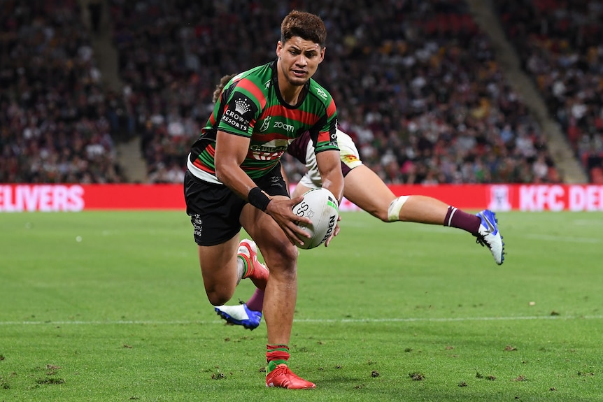 A South Sydney Rabbitohs NRL player runs towards the tryline against Manly.