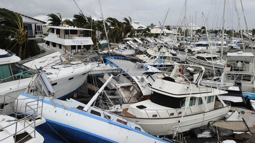 Damaged boats are stacked on top of one another at Port Hinchinbrook boat harbour in Cardwell.