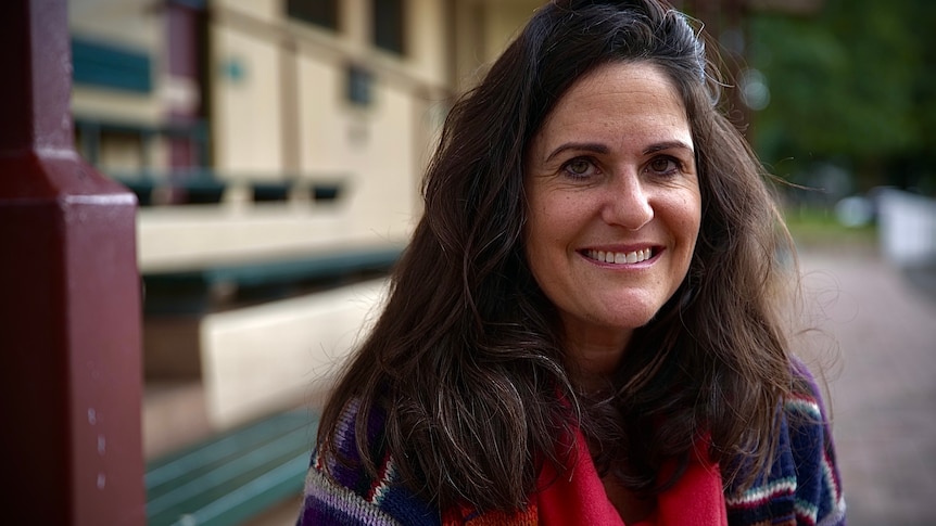 Woman with brown brown hair smiling. 