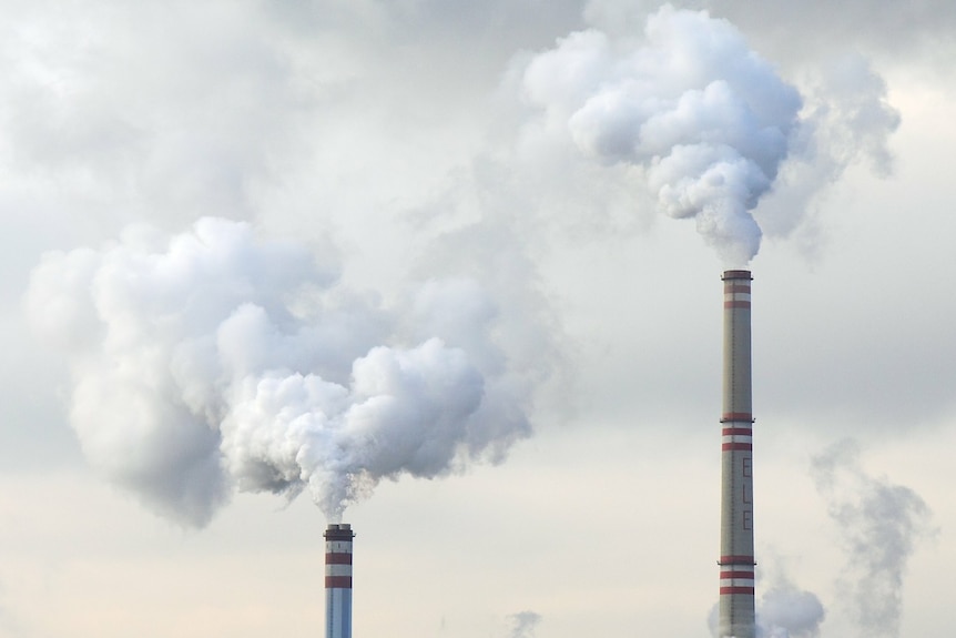 two chimneys of a power station blowing smoke