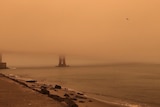 Iconic Golden Gate Bridge disappears behind golden smoke cause by out-of-control fires in California.