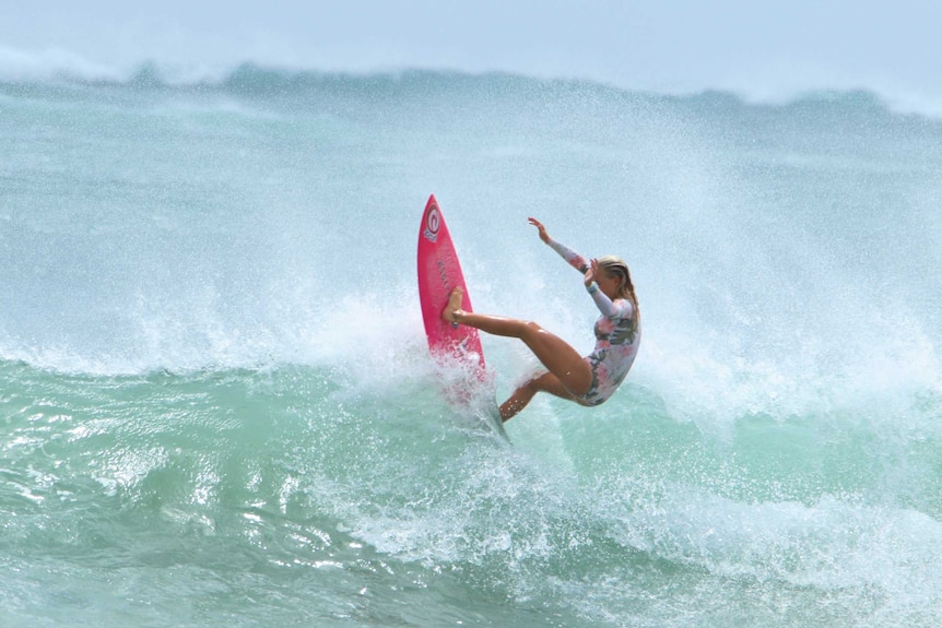 Teenager surfs a wave.