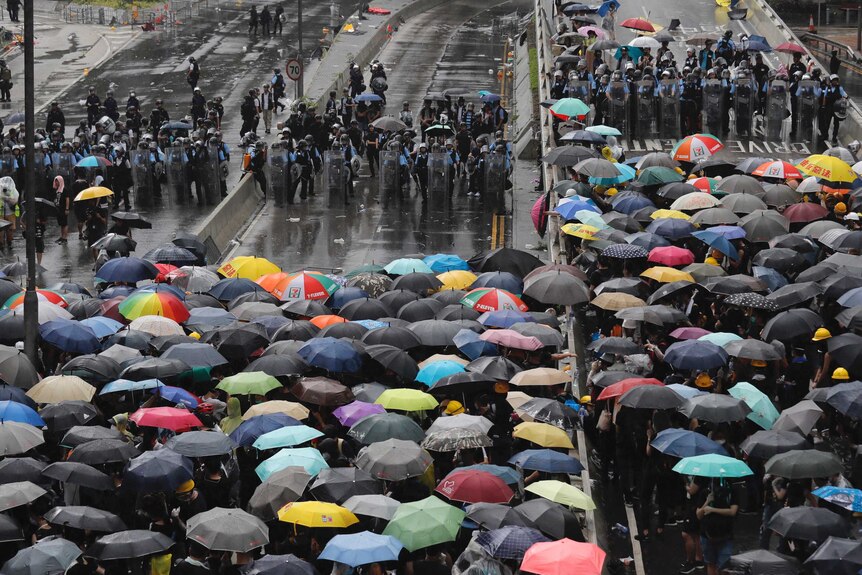 Protesters holding umbrellas face off against riot police in Hong Kong.
