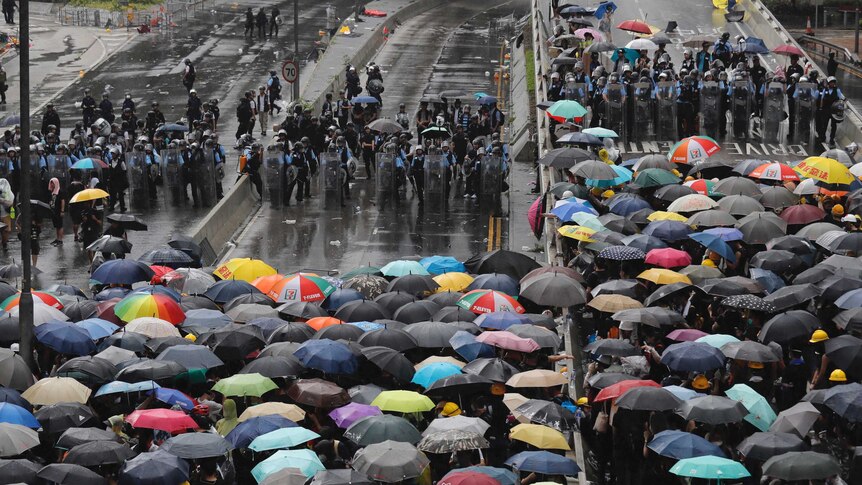 Protesters holding umbrellas face off against riot police in Hong Kong.