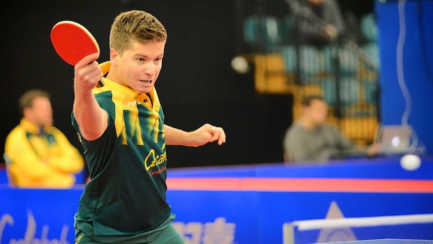 Table tennis champion Wade Townsend dressed in the green and gold Australian uniform hitting a ball during a match.