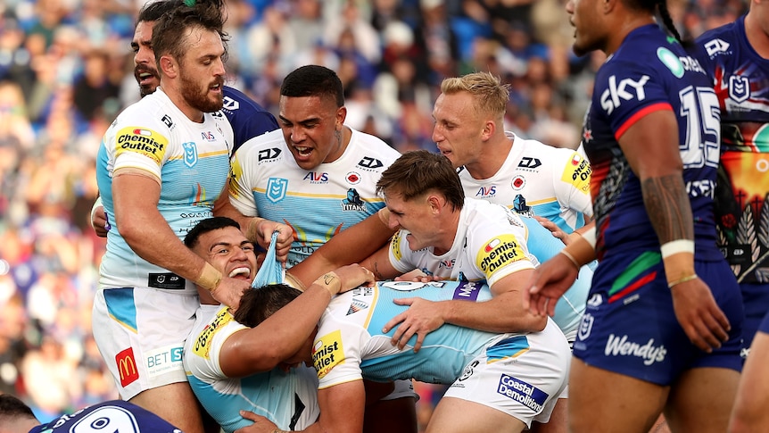 Gold Coast Titans players gather to celebrate a try.