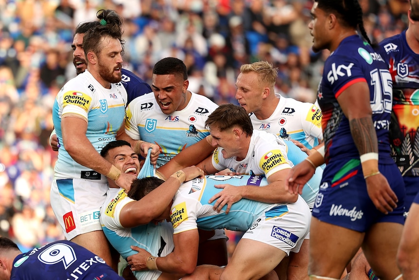 Gold Coast Titans players gather to celebrate a try.