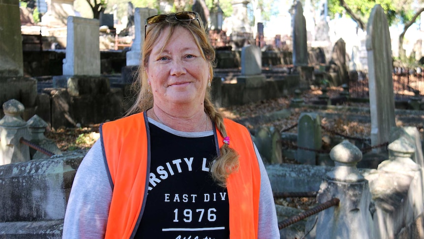 Tracey Olivieri stands in South Brisbane cemetery wearing a hi-vis vest.