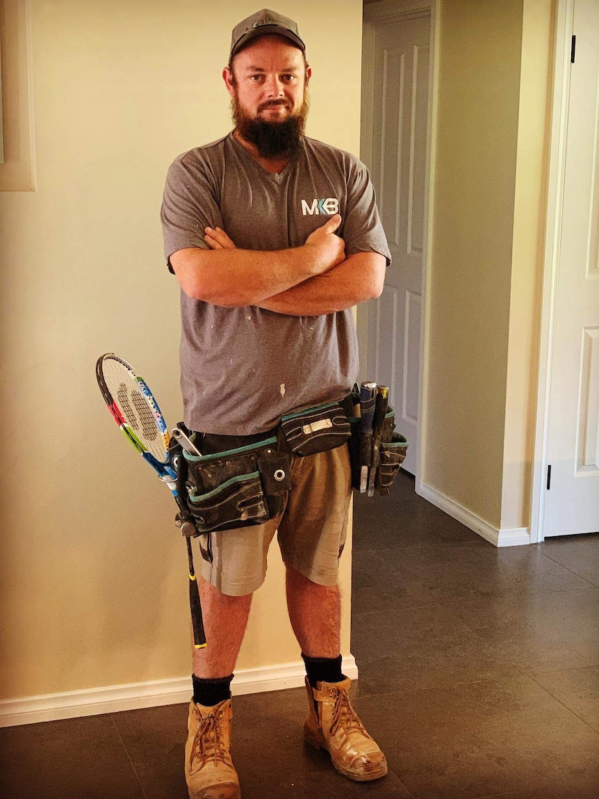 A builder standing with folded arms