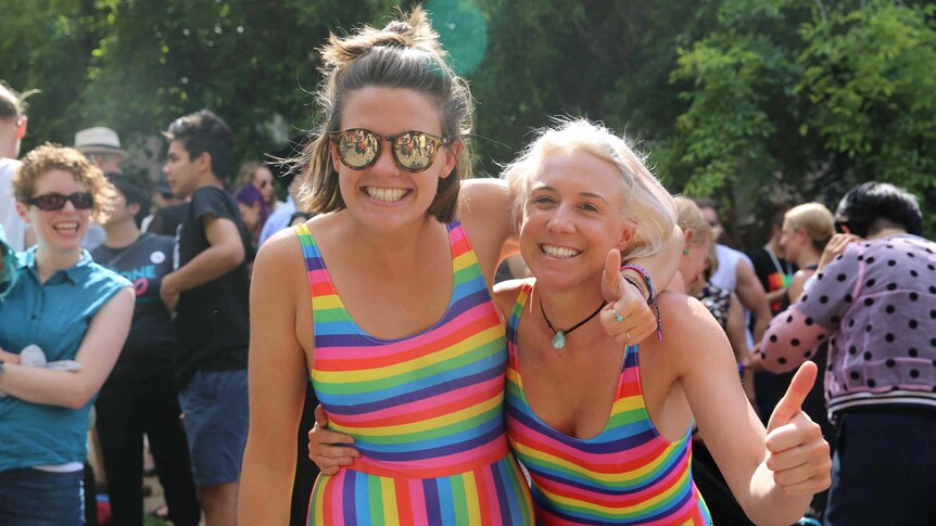 Two women in rainbow outfits.