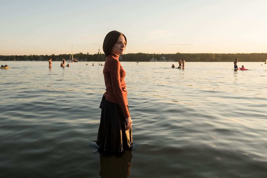 Still from Netflix's Unorthodox with Shira Haas as an orthodox jewish woman standing in a lake