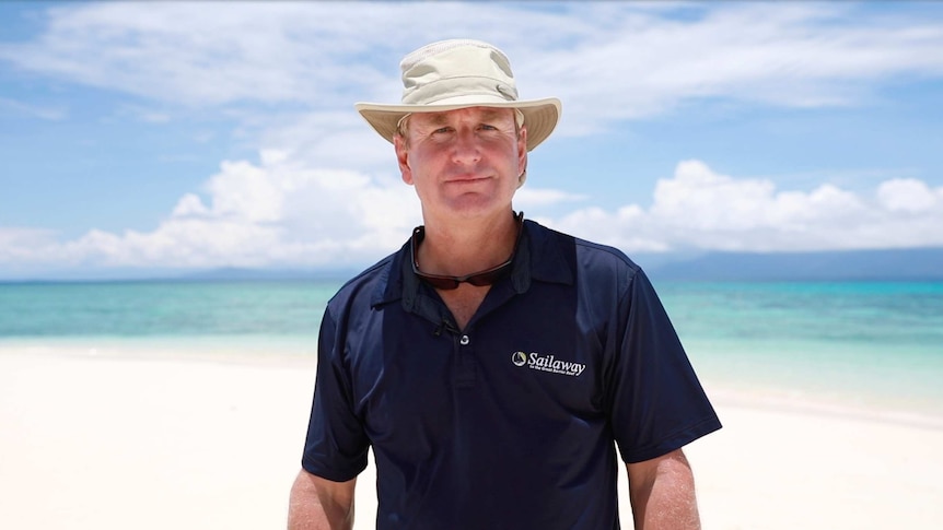 Reef tour operator Steve Edmondson stands on a beach.