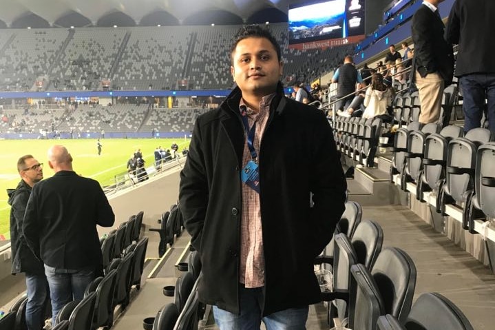 Rosan Bhattarai in the stands of a sports stadium.
