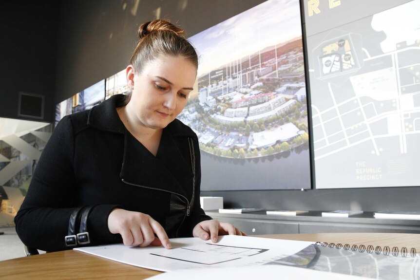 First home buyer Ashleigh Jane-Smith inspects a floor plan at a showroom in Belconnen, Canberra.