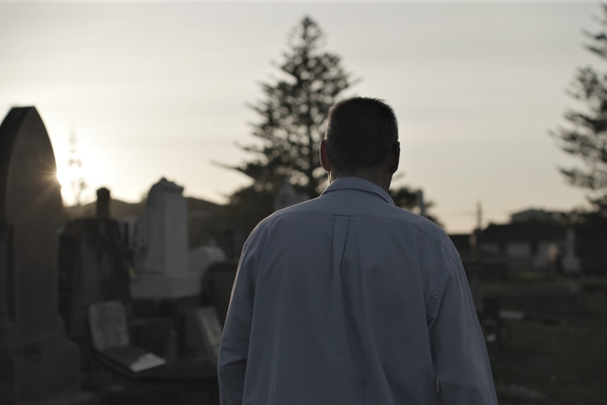 Man walks through a cemetery