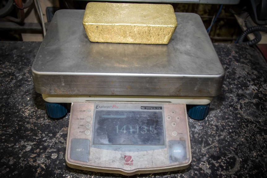 Gold bar on scales being weighed