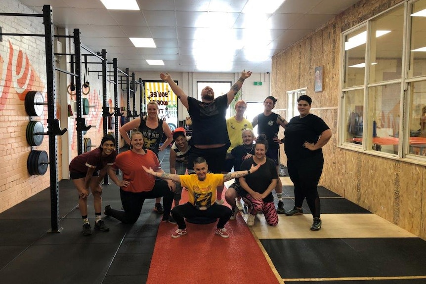 Ella Mason and gym members pose as a group at the Pony Club Gym