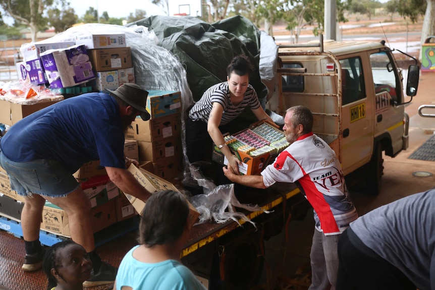 Volunteers unload from a tuck boxes of food for the South Hedland evacuation centre.