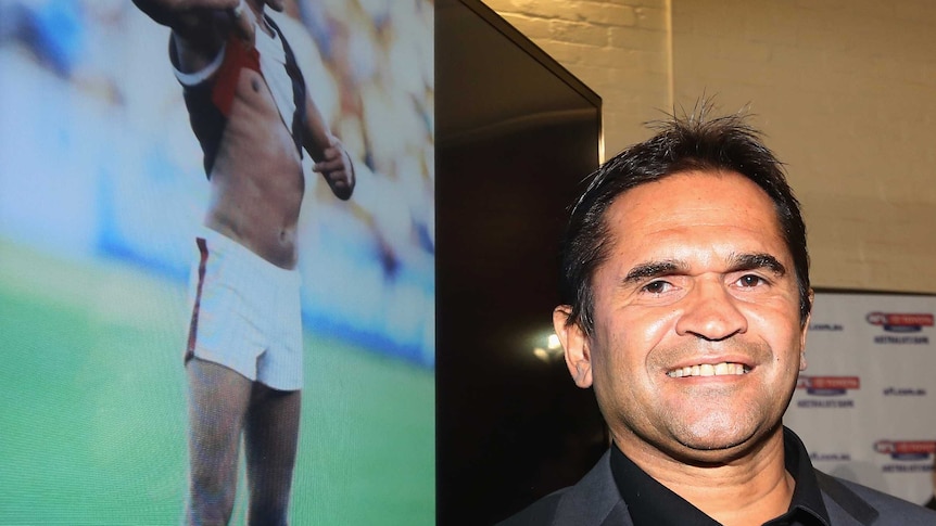 Nicky Winmar stands next to his photograph at the launch of the AFL's Indigenous round.