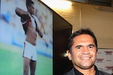 Nicky Winmar stands next to his photograph at the launch of the AFL's Indigenous round.