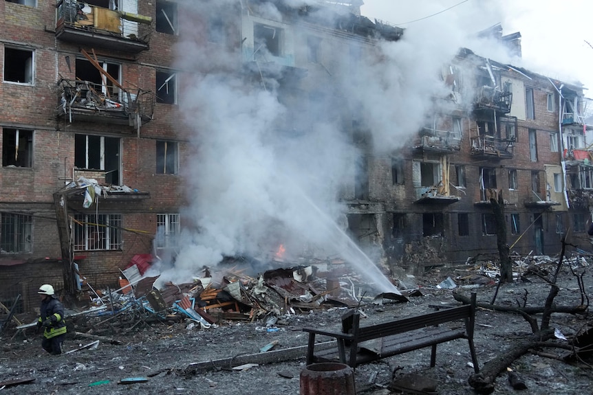 Пожарные работают на месте домов, пострадавших от российской бомбардировки.