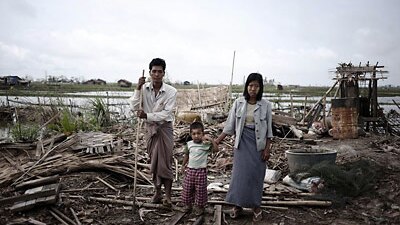 Members of family pose on the debris of their house detroyed by cyclone Nargis in a village near Kyauktan, in the delta regio...