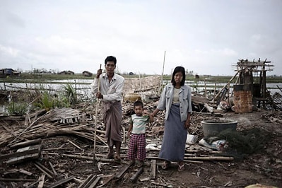 Members of family pose on the debris of their house detroyed by cyclone Nargis in a village near Kyauktan, in the delta regio...