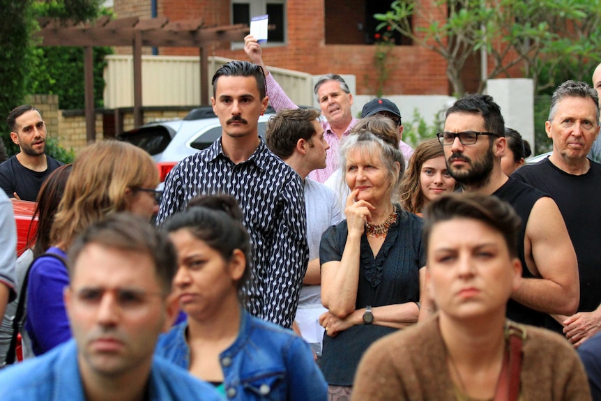 A group of adults at a house auction.