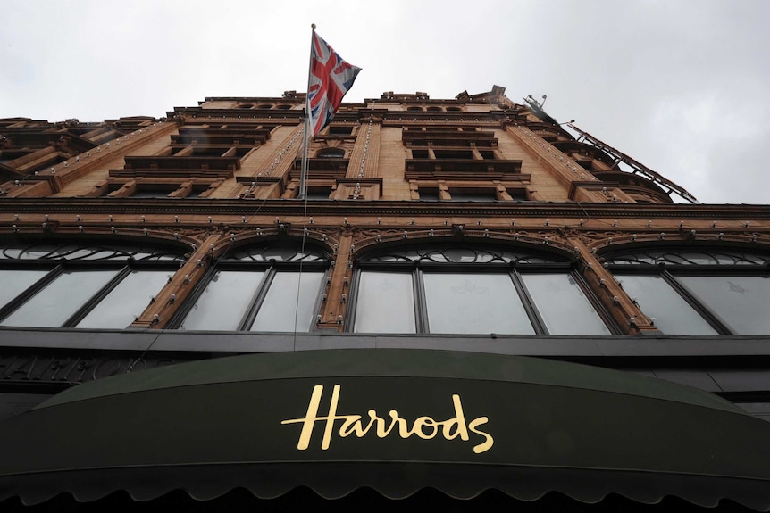 An historical-looking building featuring a dark green awning features the word "Harrods"