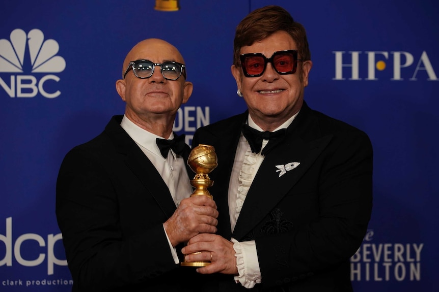 Bernie Taupin and Elton John pose backstage with their Golden Globe.