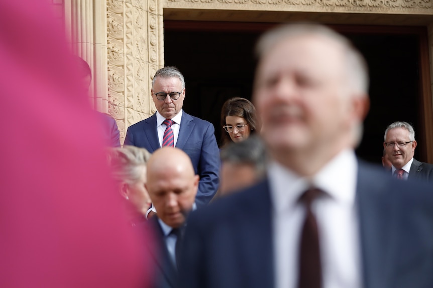 Joel Fitzgibbon looks on as Anthony Albanese speaks with a priest