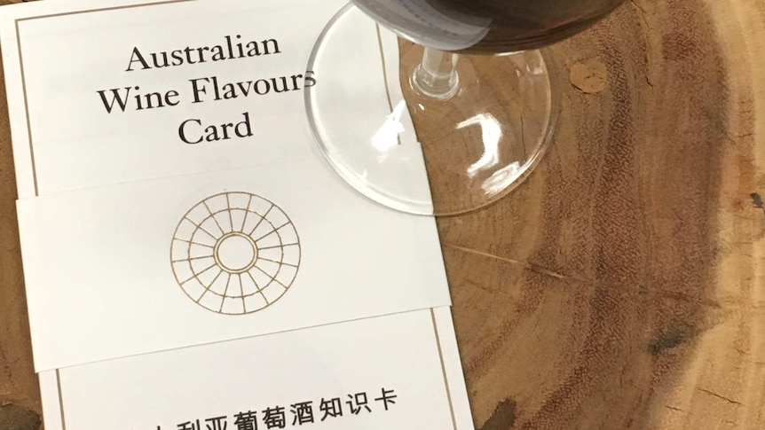 A glass of red wine next to a wine flavour card.