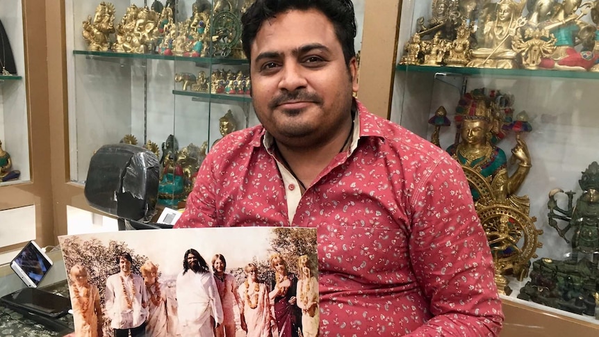 Mohit Ganeriwala, owner of Beatles' Choice, shows off a photo of John Lennon and Paul McCartney
