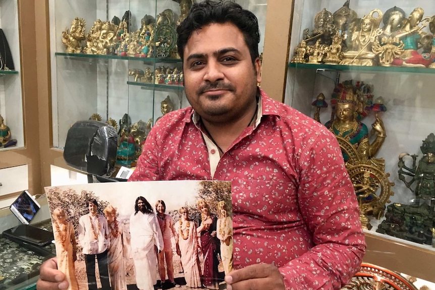 Mohit Ganeriwala, owner of Beatles' Choice, shows off a photo of John Lennon and Paul McCartney