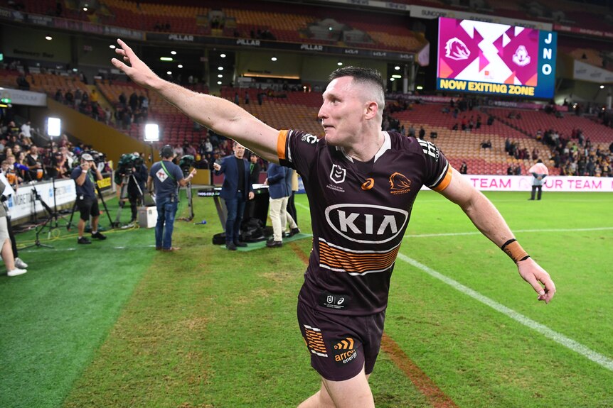 Brisbane Broncos player Tyson Gamble waves to fans on the sideline at Suncorp Stadium after an NRL game.